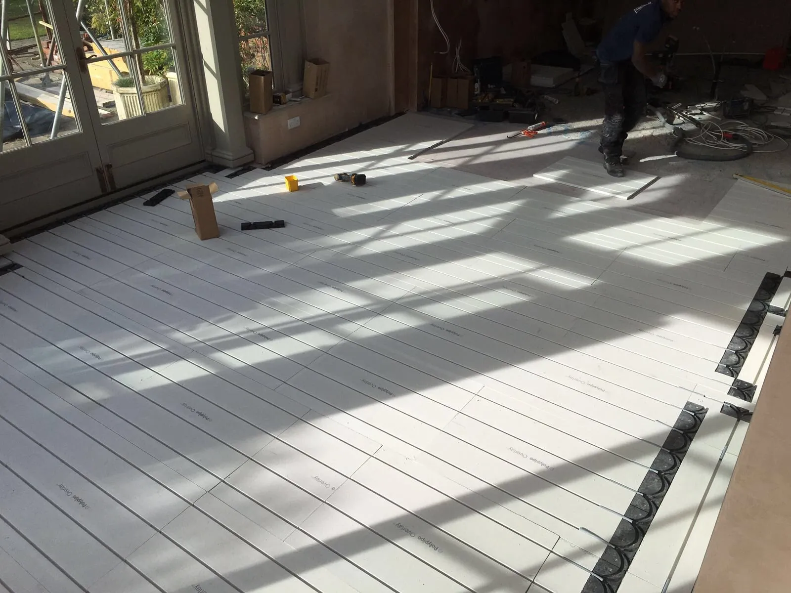 A man is working on the floor of a house.